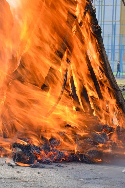 Slavische vakantie eind van de winter. Een grote terry pop van stro brandt. Zwarte rook is zichtbaar Rechtenvrije Stockfoto's