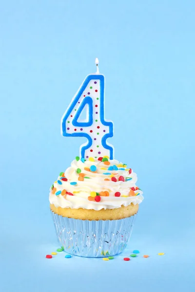 Cupcake di compleanno ghiacciato con candela numero 4 accesa e cospargere — Foto Stock