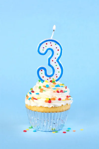 Iced birthday cupcake with with lit number 3 candle and sprinkle — Stock Photo, Image