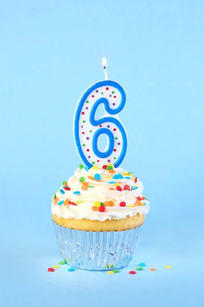 Iced birthday cupcake with with lit number 6 candle and sprinkle — Stock Photo, Image