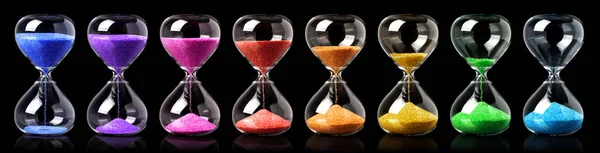 Colección de relojes de arena de colores que muestran el paso del tiempo — Foto de Stock