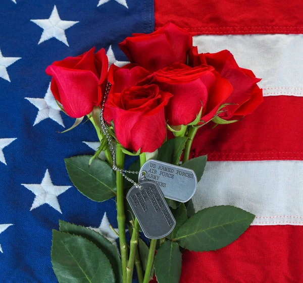 Americká vlajka s růžemi a vojenskými psními značkami — Stock fotografie