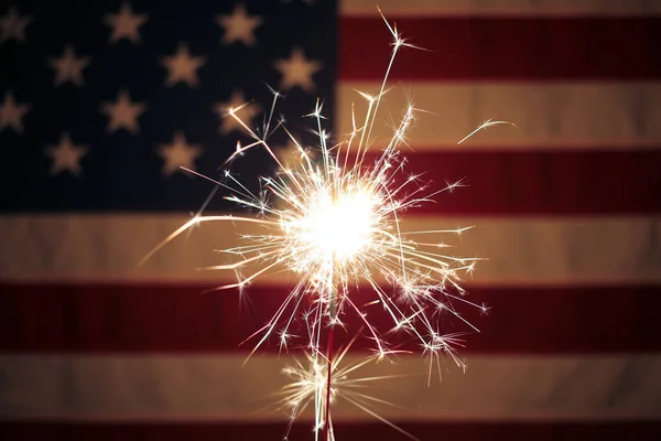 Lit sparkler en frente de la bandera americana para el 4 de julio celebrat — Foto de Stock