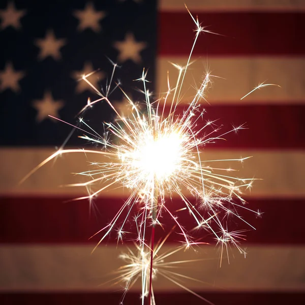 Lit sparkler en frente de la bandera americana para el 4 de julio celebrat — Foto de Stock