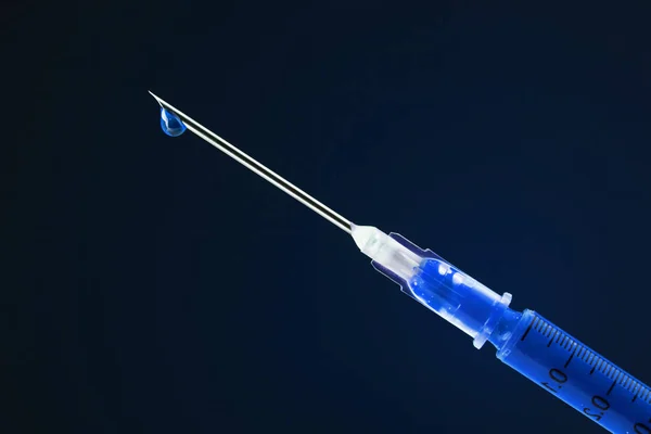 Spruta fylld med blått läkemedel och droppande från nålen — Stockfoto