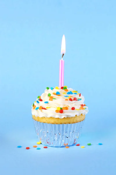 Cupcake di compleanno ghiacciato con candela accesa e spruzzi — Foto Stock
