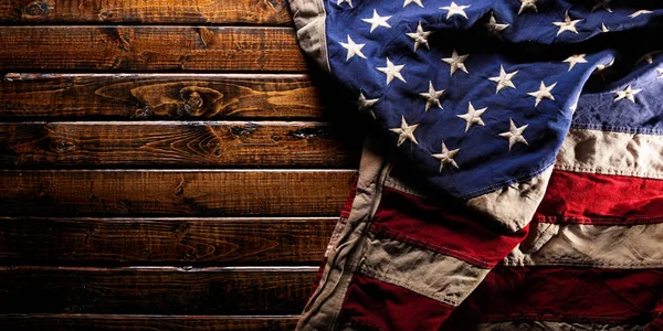 Gammal och sliten amerikansk flagga på mörk trä bakgrund — Stockfoto