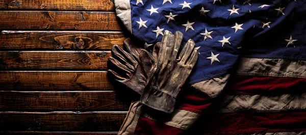 Luvas de trabalho velhas e usadas na grande bandeira americana - Dia do trabalho de volta — Fotografia de Stock
