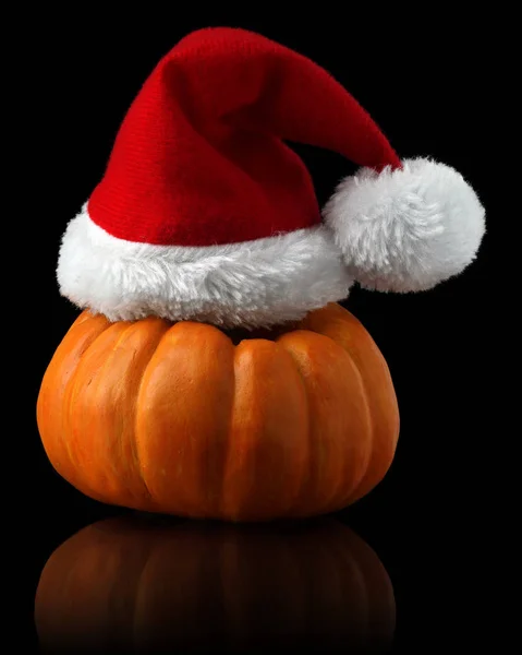 Una sola calabaza naranja con sombrero de Navidad Santa —  Fotos de Stock