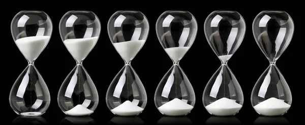 Collection of hourglasses with white sand showing the passage of — Stock Photo, Image