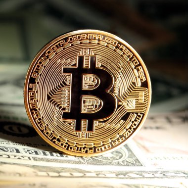 Parlak altın bitcoin, para yığınları üzerinde dengelenmiş. Zenginlik,