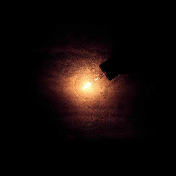 Ročník staré žárovky matně osvětlené na hrubém tmavém pozadí. Nápad, — Stock fotografie