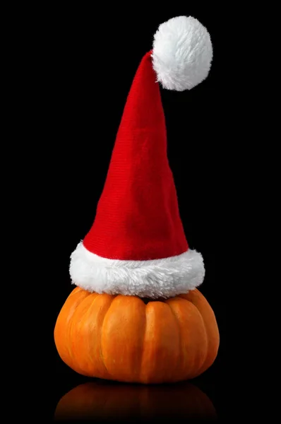 Una sola calabaza naranja con sombrero de Navidad Santa —  Fotos de Stock