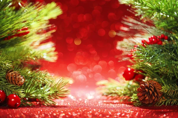 Christmas tree branches on glittering red background — Stock Photo, Image