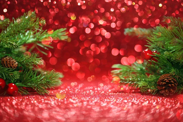 Karácsonyfa ágak csillogó piros háttér — Stock Fotó