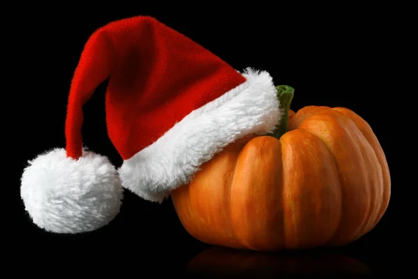 Einzelner orangefarbener Kürbis mit Weihnachtsmütze — Stockfoto