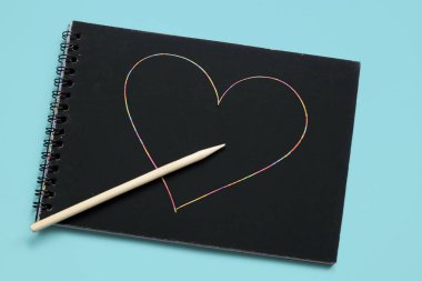 Siyah çarşaf ve ahşap kazıyıcı ile Not Defteri parlak pürüzsüz bir arka plan, mektup yazmak için bir yer, siyah kağıt üzerine metin yazmak