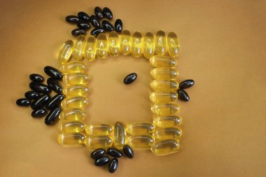 Vitaminler sarı balık yağı oval şekilli, sağlıklı balık yağı kayıtları için balık ve boş alan şeklinde parlak bir arka plan üzerinde yalan