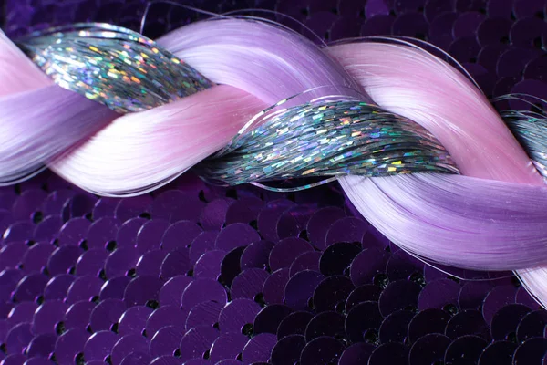 スパンコールの背景に光沢のある銀 ピンクと紫の糸のピグテール — ストック写真