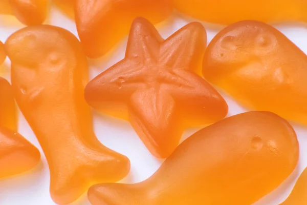 Orange fish and stars baby vitamins macro view bright background of childrens delicious healthy marmalades