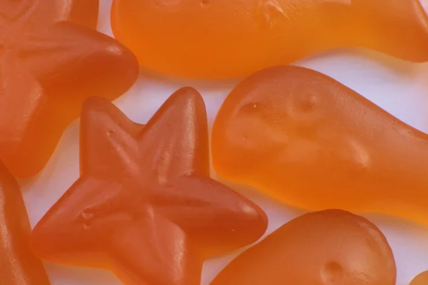 Orange fish and stars baby vitamins macro view bright background of childrens delicious healthy marmalades