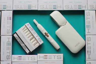 Nizhny Novgorod, Volga Region / Rusya - 18 Temmuz 2019: Iqos tütün ısıtma sistemi, parlak bir arka plan üzerinde Heets birçok paketleri sopa