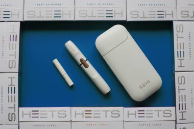 Nizhny Novgorod, Volga Region / Rusya - 18 Temmuz 2019: Iqos tütün ısıtma sistemi, parlak bir arka plan üzerinde Heets birçok paketleri sopa