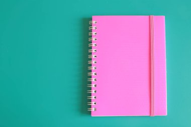 Sulu pembe not defteri ve parlak bir arka plan üzerinde notlar için alan