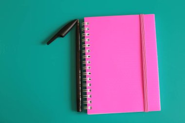 Sulu pembe not defteri ve parlak bir arka plan üzerinde notlar için alan