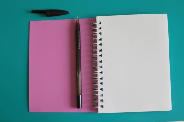 Parlak arka plandaki kayıtlar için damalı bir yerde bulunan not defteri beyaz boş sayfalar