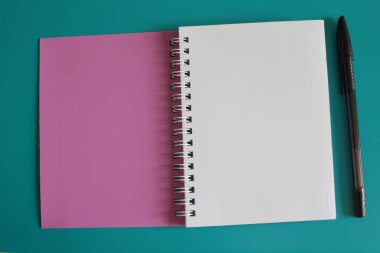 Parlak arka plandaki kayıtlar için damalı bir yerde bulunan not defteri beyaz boş sayfalar