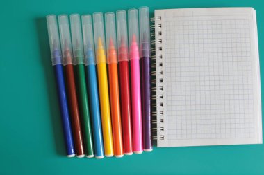 Not defteri ve parlak bir arka plan üzerinde çok renkli işaretleri bir sürü