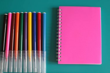 Not defteri ve parlak bir arka plan üzerinde çok renkli işaretleri bir sürü