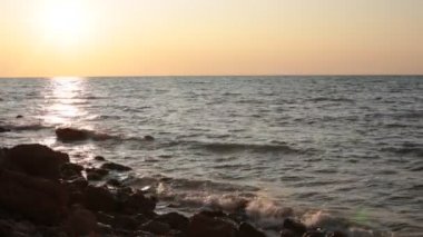 Deniz koyu büyük taşlar ve dalgalar gün batımı ve küçük esinti