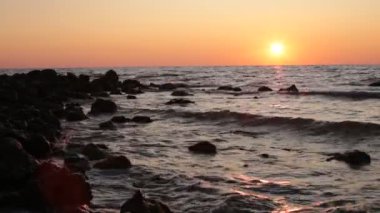 Deniz koyu büyük taşlar ve dalgalar gün batımı ve küçük esinti