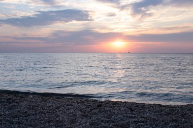 Denizde parlak gün batımı hava ve su dar bir kıyı şeridi çok, su yakın şafak gökyüzünde güneş renkleri bir degrade