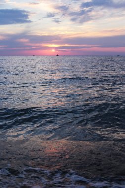 Denizde parlak gün batımı hava ve su dar bir kıyı şeridi çok, su yakın şafak gökyüzünde güneş renkleri bir degrade