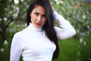 Beyaz bir balıkçı bahar çiçekli leylak ve elma ağaçları uzun siyah saçlı genç gülümseyen kadın