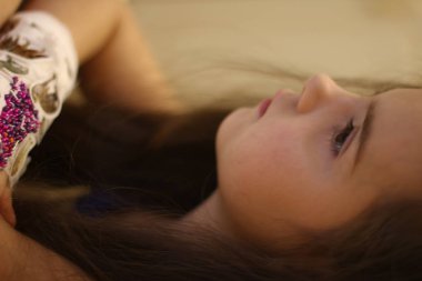 Küçük bir kızın elinde alçı, boya ve boncuk ve çıkartmalar ile alçı döküm süslemeleri