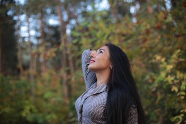 bir sonbahar yürüyüşünde uzun siyah saçlı bir kız portresi