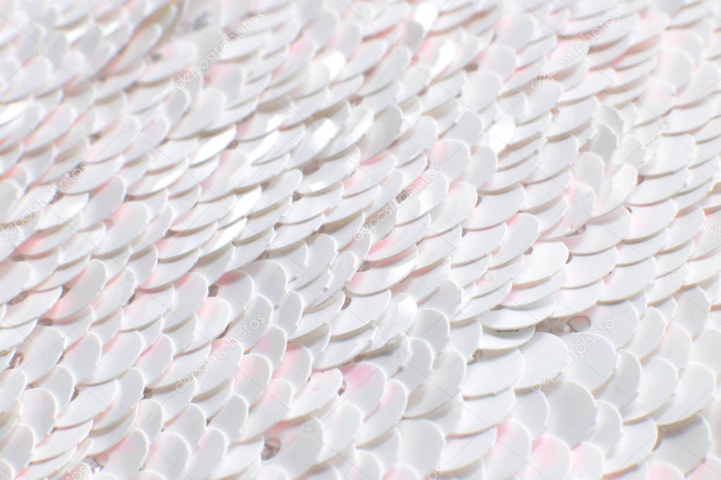 Background of white sequins glitter, texture with flickering iridescent glitter