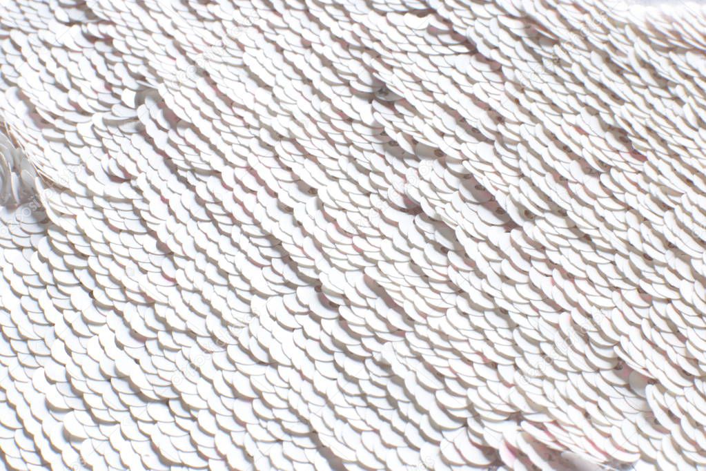 Background of white sequins glitter, texture with flickering iridescent glitter