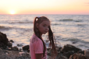 Serin 7 yaşındaki kız deniz kenarında dinleniyor.