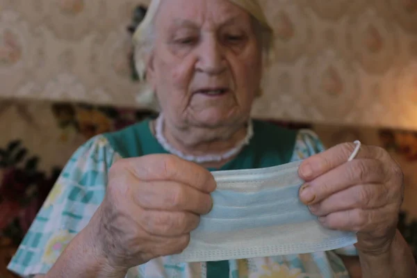 Maschera Medica Blu Nelle Mani Una Vecchia Nonna Dai Capelli — Foto Stock