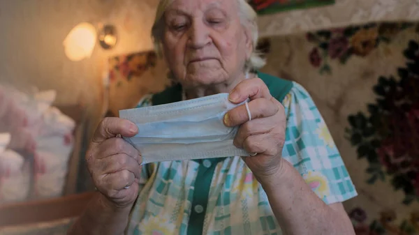 Máscara Médica Azul Nas Mãos Uma Velha Avó Cabelos Grisalhos — Fotografia de Stock