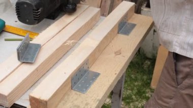 İnşaat tahtalarının hazırlanması, insanların elleri tahta kirişlerle çalışır.