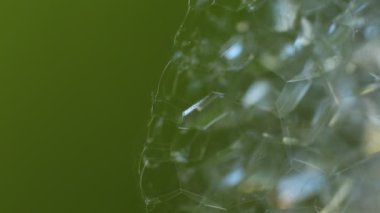 Soyut makro video arka plan sabun köpükleri, parlayan cam parçaları, parıldayan güneş ışınlı buz.