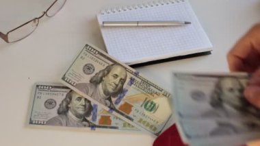 100 dolarlık banknotlar halinde bir sürü para, beyaz arka planda para saymak.