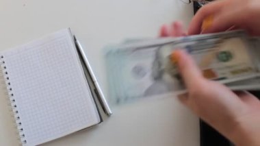 100 dolarlık banknotlar halinde paraları say.