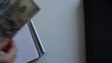 100 dolarlık banknotlar halinde paraları say.